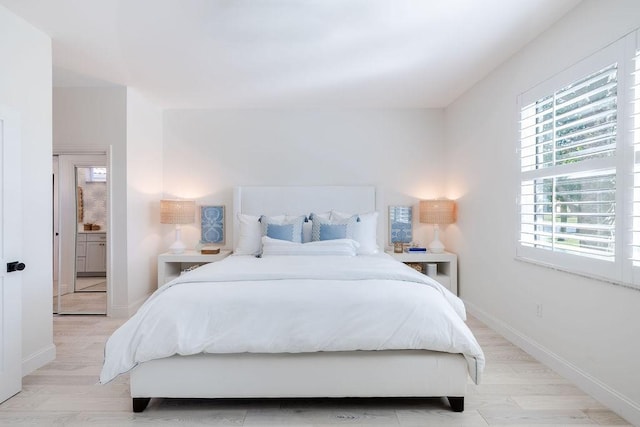 bedroom with light wood-type flooring and baseboards