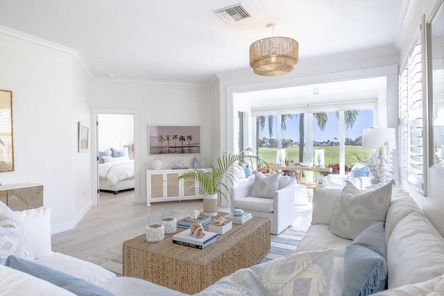 living room featuring visible vents, wood finished floors, baseboards, and ornamental molding