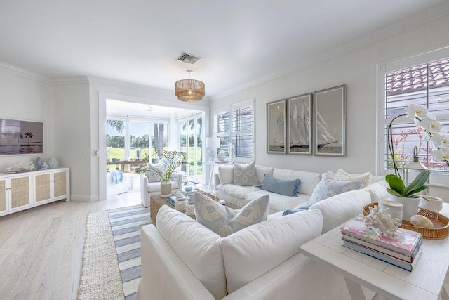 living room featuring visible vents, wood finished floors, baseboards, and ornamental molding