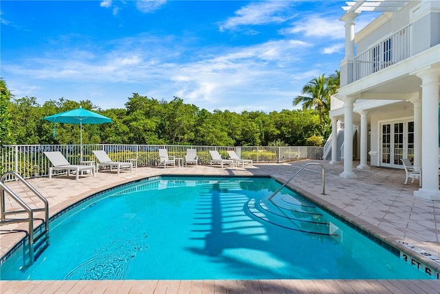 view of swimming pool featuring a patio and french doors