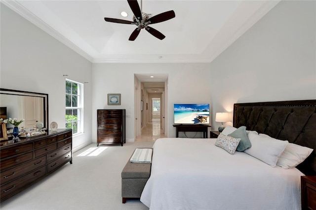 bedroom with a raised ceiling, ornamental molding, light colored carpet, and ceiling fan