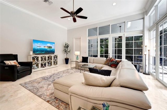 living room with crown molding, plenty of natural light, and a towering ceiling