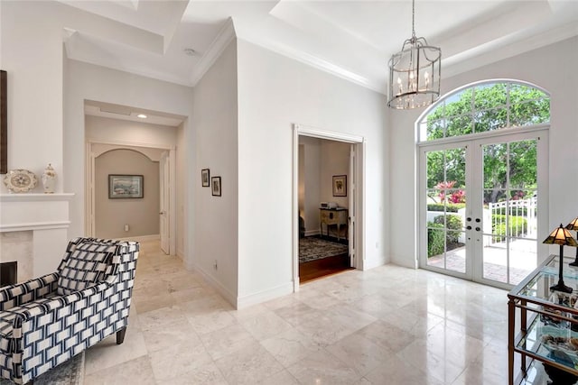 foyer entrance with french doors, plenty of natural light, a towering ceiling, and a tray ceiling