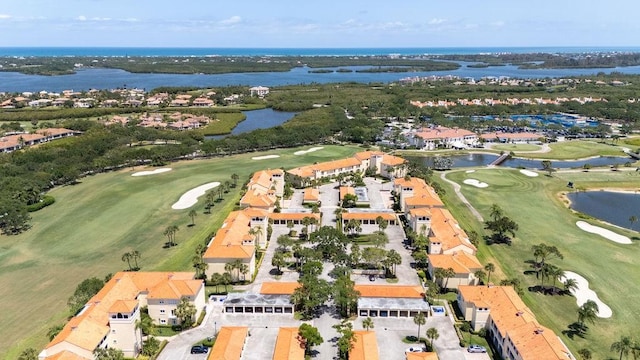 drone / aerial view featuring a water view, golf course view, and a residential view