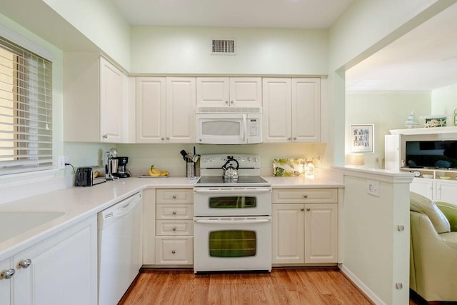 kitchen with visible vents, light countertops, white cabinets, white appliances, and light wood-style flooring