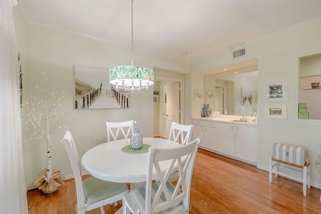 dining room featuring visible vents, crown molding, a notable chandelier, and light wood-type flooring