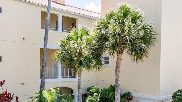 view of home's exterior featuring stucco siding, a balcony, and a tile roof