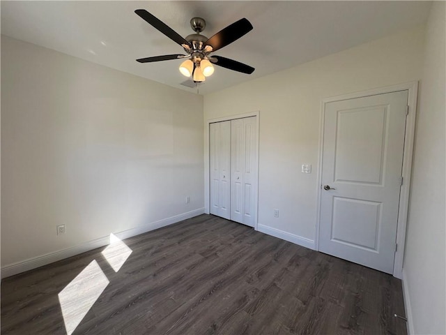 unfurnished bedroom featuring a closet, ceiling fan, and dark wood-type flooring