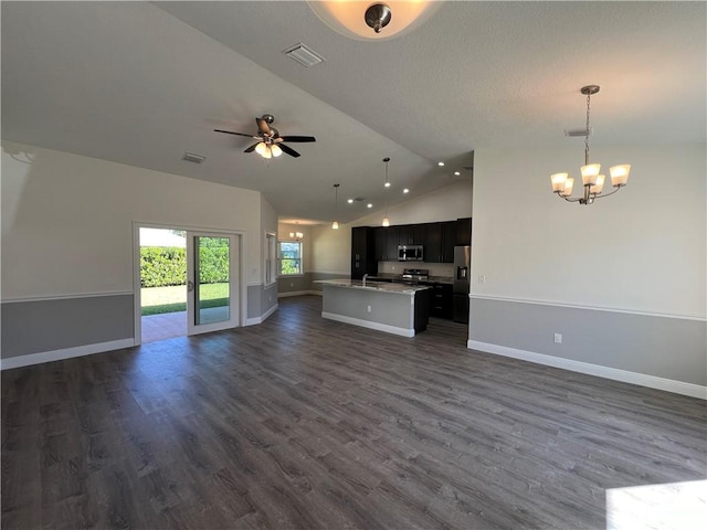 unfurnished living room featuring dark hardwood / wood-style flooring, vaulted ceiling, and ceiling fan with notable chandelier