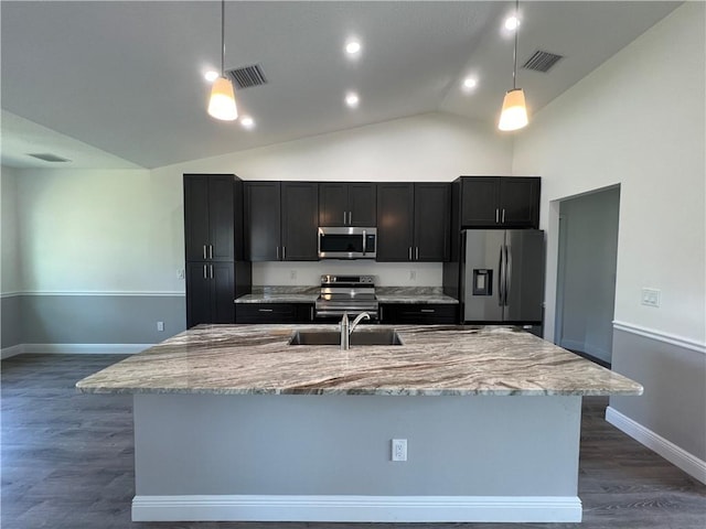 kitchen featuring stainless steel appliances, a center island with sink, decorative light fixtures, and sink