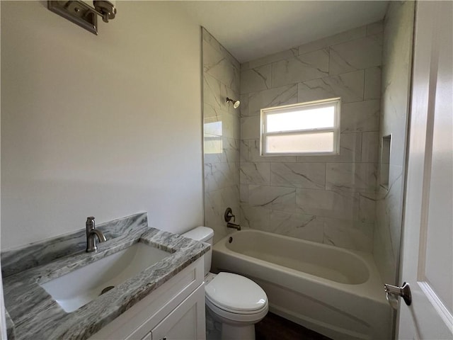 full bathroom featuring toilet, tiled shower / bath combo, and vanity