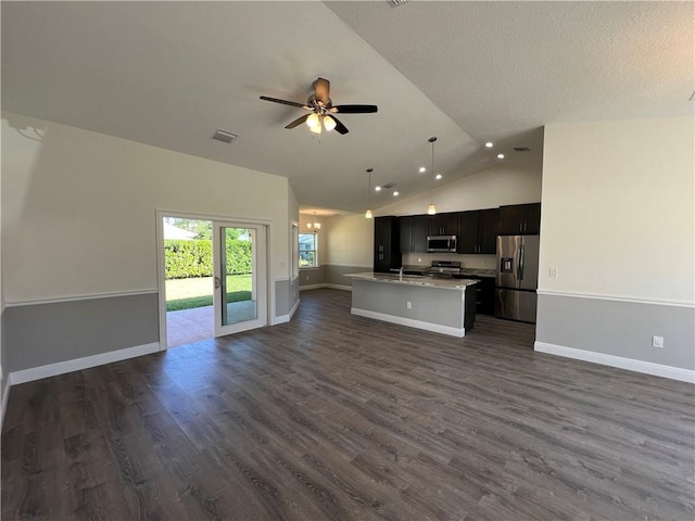 kitchen with ceiling fan, hanging light fixtures, a center island with sink, dark hardwood / wood-style flooring, and appliances with stainless steel finishes