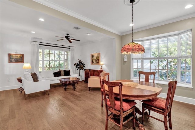 dining area with wood-type flooring, ceiling fan, and crown molding