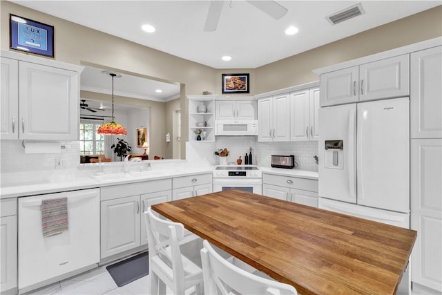 kitchen with kitchen peninsula, white appliances, white cabinetry, and sink