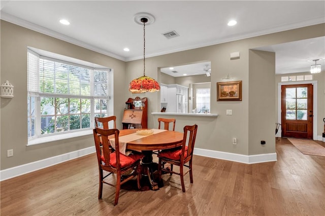 dining area with ceiling fan, light hardwood / wood-style floors, and ornamental molding