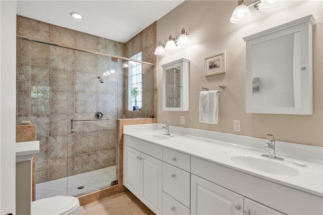 bathroom featuring vanity, toilet, and an enclosed shower