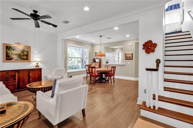 living room featuring ceiling fan, light hardwood / wood-style floors, and ornamental molding