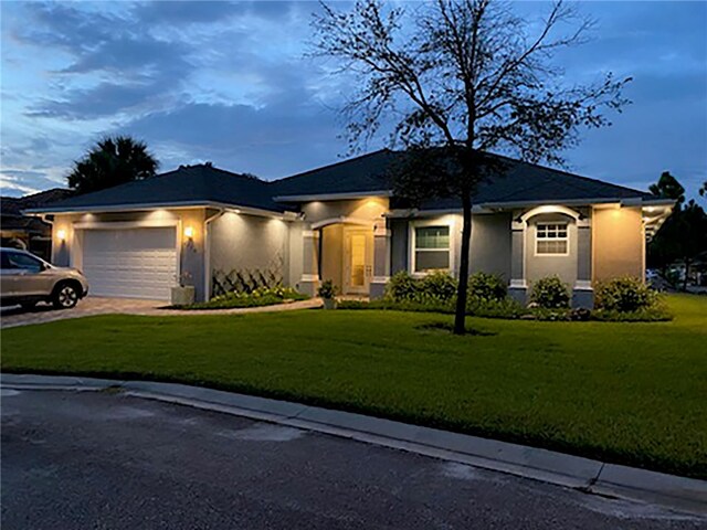 prairie-style home with a garage and a lawn