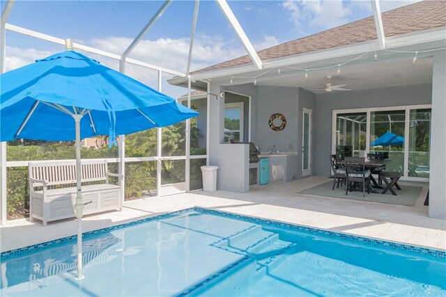 view of pool with glass enclosure, a patio area, and ceiling fan