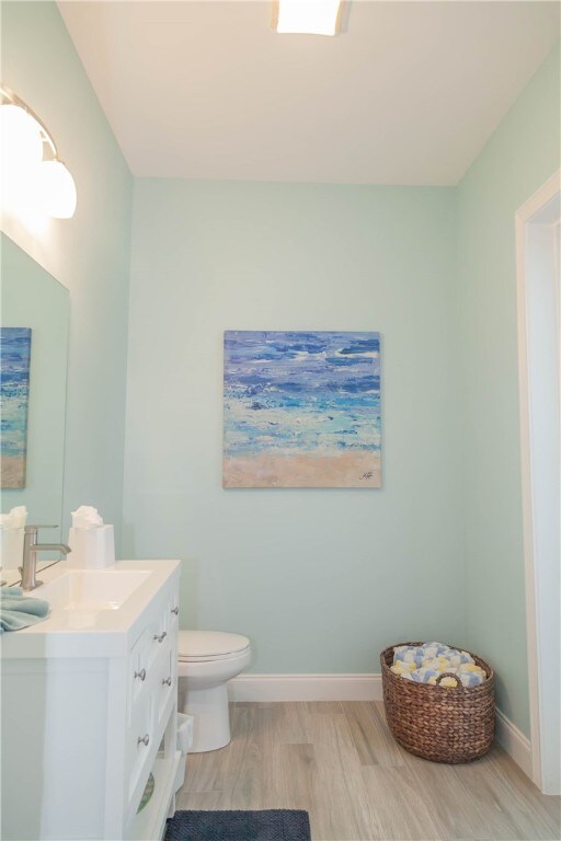 bathroom featuring hardwood / wood-style floors, vanity, and toilet