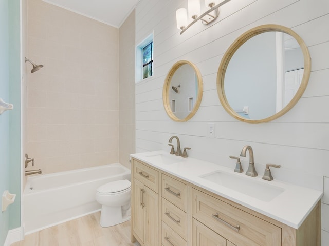 full bathroom with wood walls, wood-type flooring, vanity, and toilet