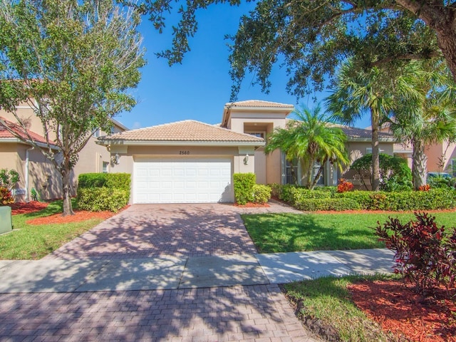 mediterranean / spanish-style house with a garage and a front yard