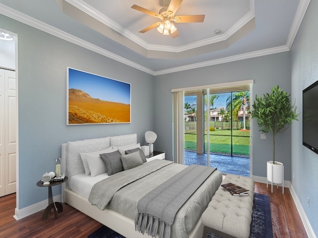 bedroom with crown molding, access to exterior, dark wood-type flooring, a tray ceiling, and ceiling fan