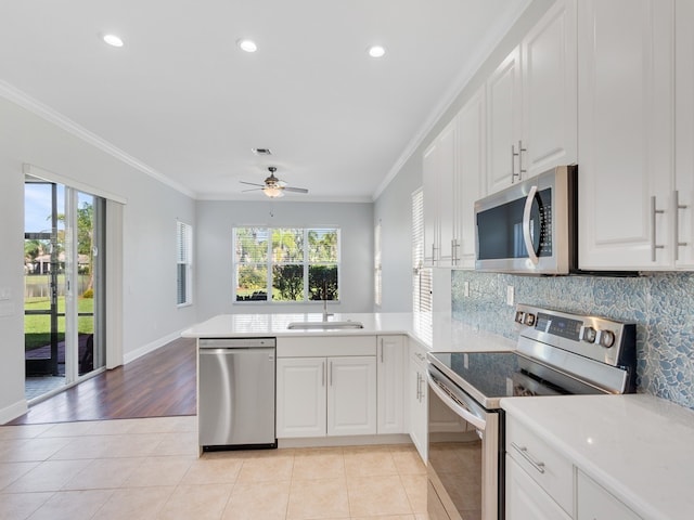 kitchen with kitchen peninsula, appliances with stainless steel finishes, sink, and plenty of natural light