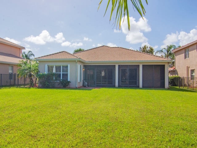 rear view of property with a sunroom and a yard