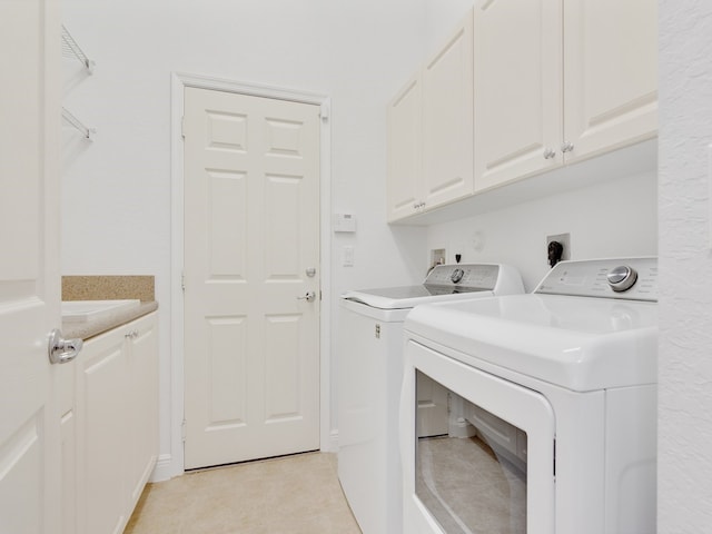 laundry area featuring cabinets, washer and clothes dryer, and light tile patterned flooring