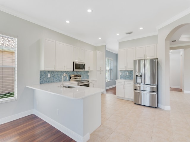 kitchen featuring backsplash, appliances with stainless steel finishes, and white cabinets