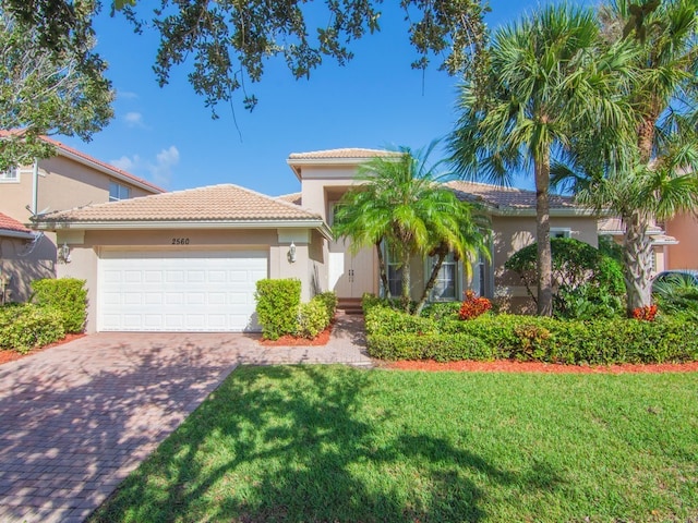 mediterranean / spanish house with a front lawn and a garage