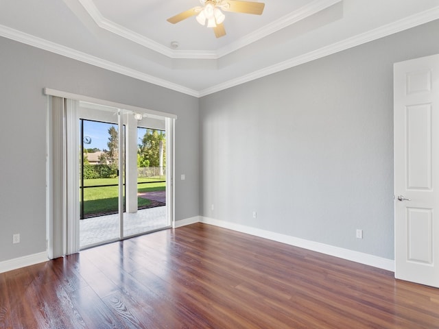 unfurnished room featuring dark hardwood / wood-style floors, crown molding, a tray ceiling, and ceiling fan