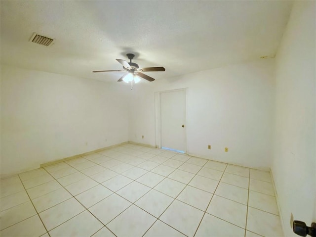 spare room featuring ceiling fan and light tile patterned flooring