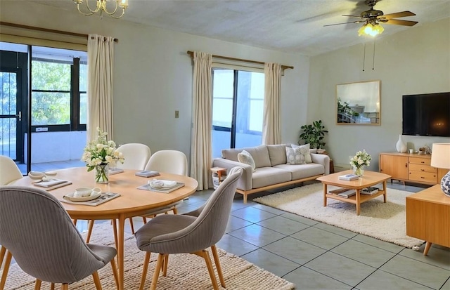 dining room featuring ceiling fan with notable chandelier, light tile patterned floors, and a wealth of natural light