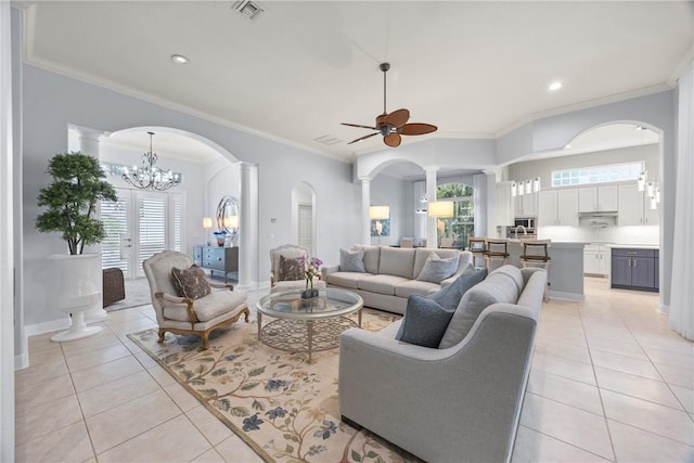 tiled living room with crown molding and ceiling fan with notable chandelier