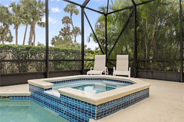 view of pool with a lanai, a patio area, and an in ground hot tub