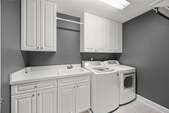 laundry room with washer and dryer, sink, light tile patterned flooring, and cabinets