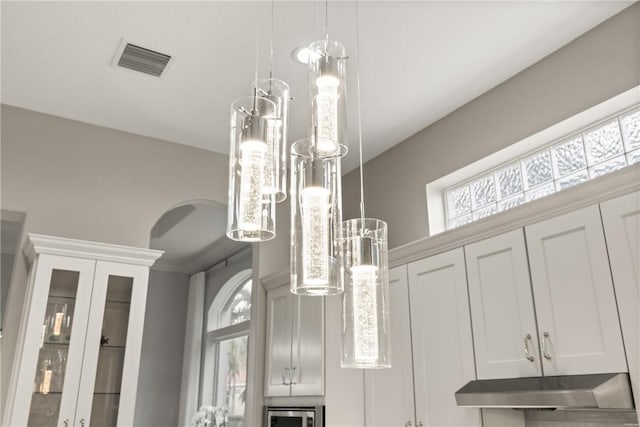 room details featuring white cabinets and decorative light fixtures