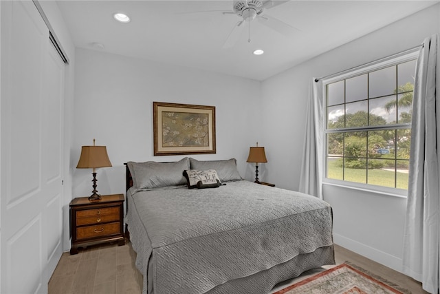 bedroom featuring ceiling fan, a closet, and light hardwood / wood-style flooring