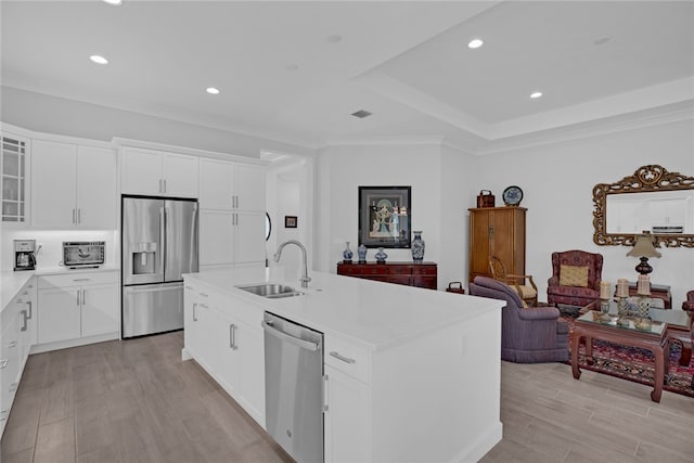 kitchen with sink, appliances with stainless steel finishes, an island with sink, crown molding, and white cabinets