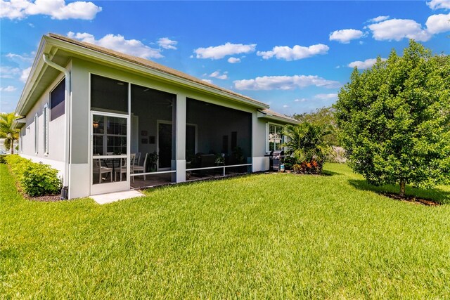 rear view of property with a sunroom and a yard