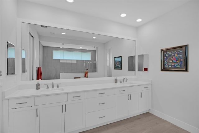 bathroom with walk in shower, wood-type flooring, and vanity