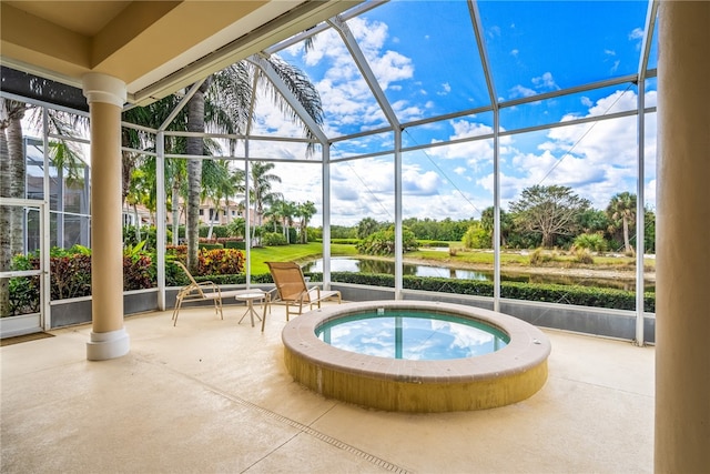 view of pool featuring a patio area, a water view, a lanai, and an in ground hot tub