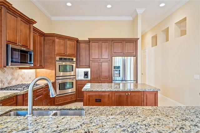 kitchen featuring ornamental molding, stainless steel appliances, sink, and light stone counters