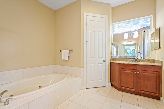 bathroom featuring vanity, tiled bath, a notable chandelier, and a healthy amount of sunlight