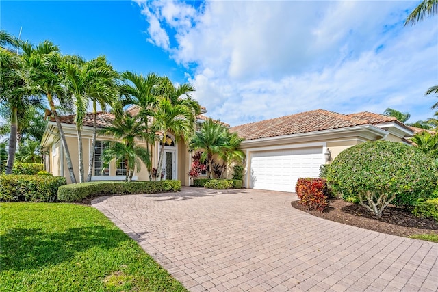 mediterranean / spanish home with a garage and a front yard