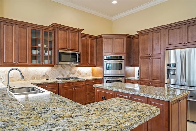 kitchen with light stone counters, sink, crown molding, backsplash, and appliances with stainless steel finishes