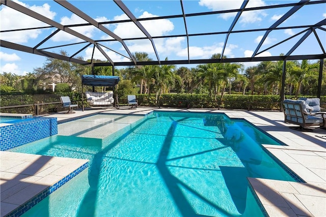 view of pool with glass enclosure and a patio