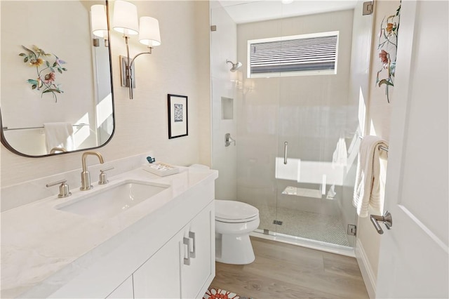 bathroom with vanity, a shower with shower door, wood-type flooring, and toilet